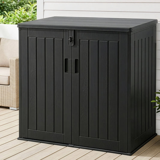 Black outdoor storage cabinet on a wooden deck with a white wall and greenery in the background.